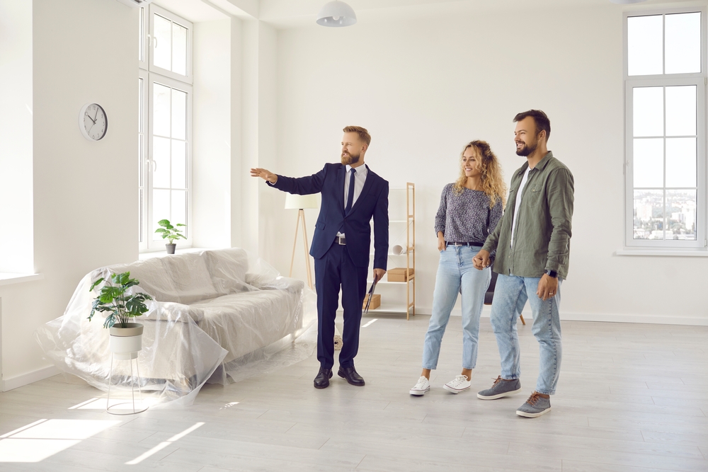 Boyfriend and girlfriend or husband and wife who plan property investment looking at lovely modern spacious home